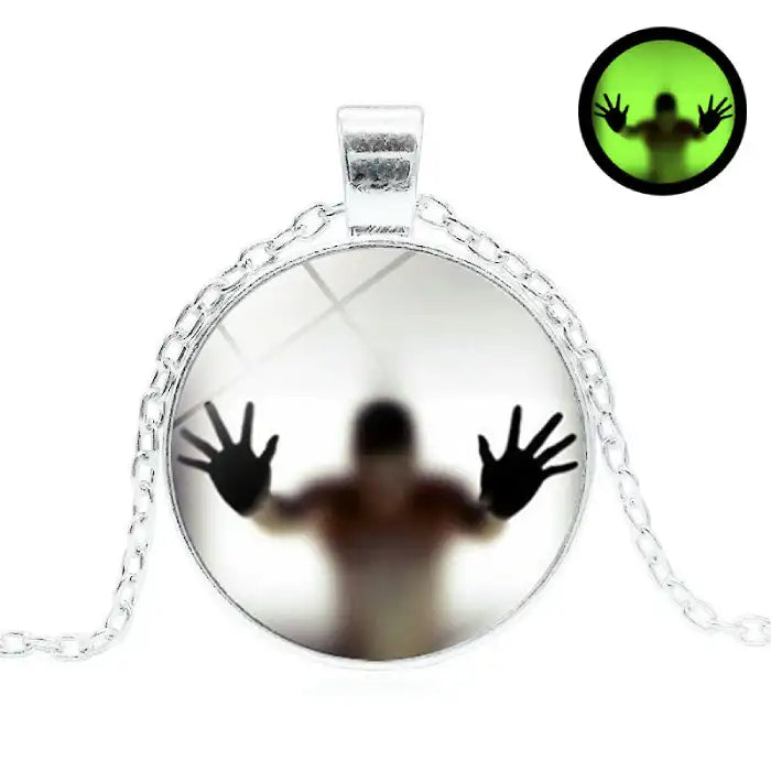 Halloween Glow necklace featuring eerie figure with silver chain and haunting glow background.