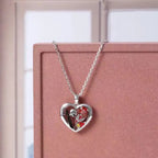 Halloween Gothic necklace with heart pendant displayed on pink box near window background