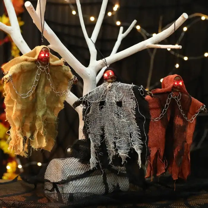 Halloween Hanging Ghost decor with glowing red eyes, ragged robes, and hanging chains on white tree display.