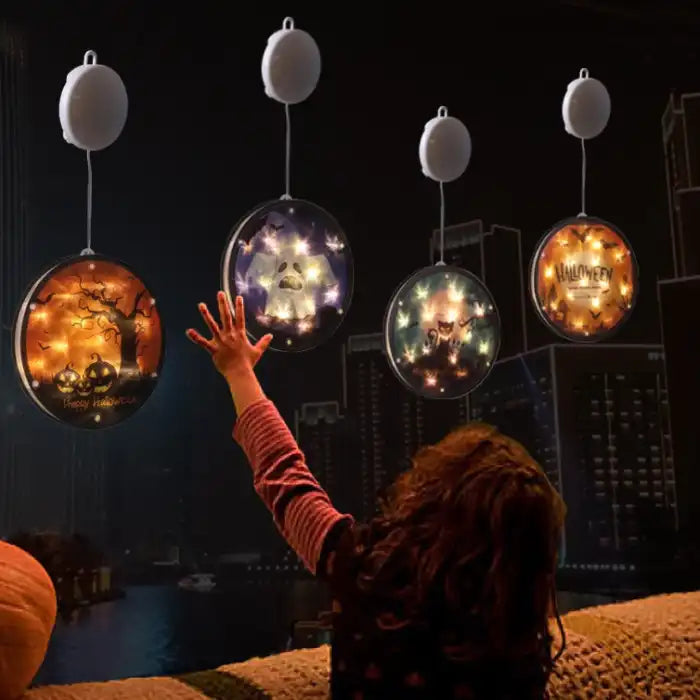 Halloween Lanterns glowing over nighttime city skyline with child reaching toward hanging decorations.