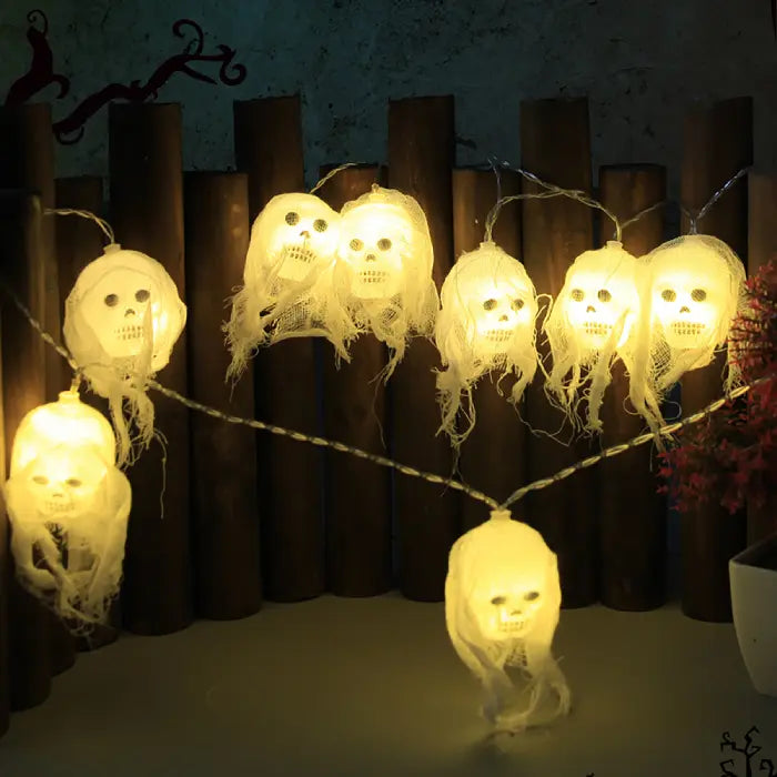 Halloween lights with yellow glowing skull heads on string for party or outdoor decoration.