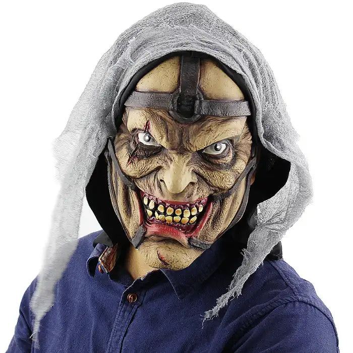 Halloween mask showing hooded ghoul with decaying face, yellow teeth, and sinister expression.