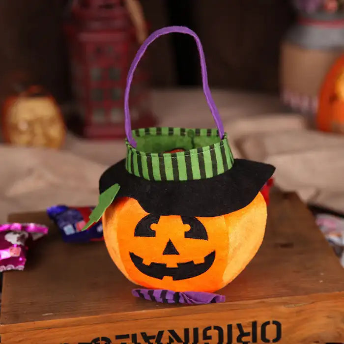 Halloween pumpkin candy bag with black hat and carved jack-o-lantern face in bright orange