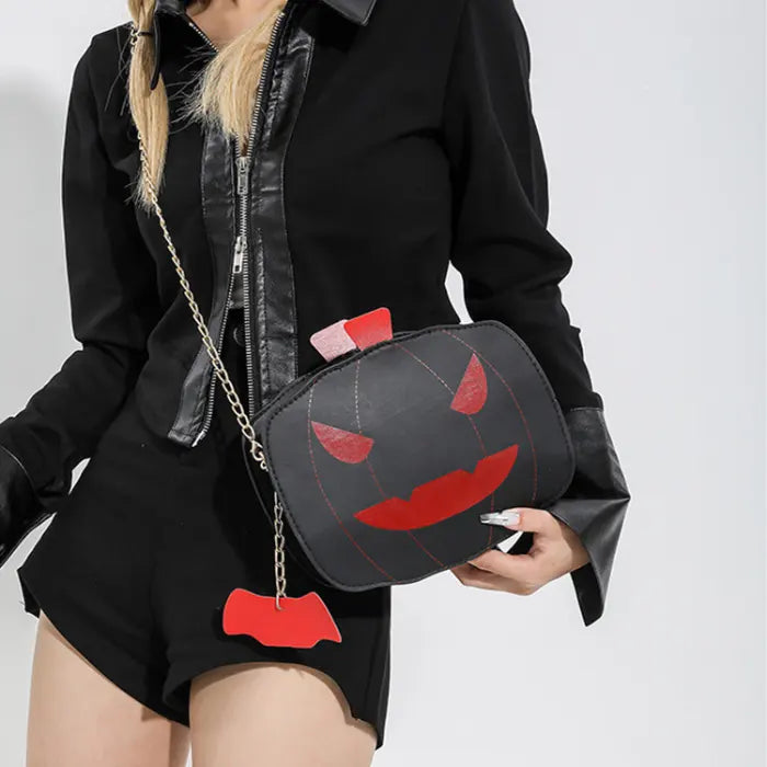 Halloween Pumpkin Head bag in black and red with gold chain strap worn crossbody