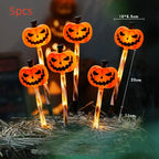 Halloween Pumpkin LED lights with single jack-o'-lantern face glowing orange in outdoor yard setting