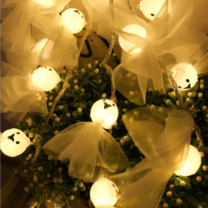 Halloween string lights featuring cute glowing ghost figures wrapped in sheer white cloth