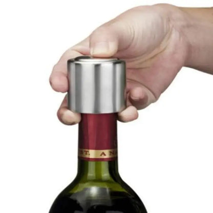 Hand using stainless steel wine stopper to seal an open wine bottle for airtight preservation.