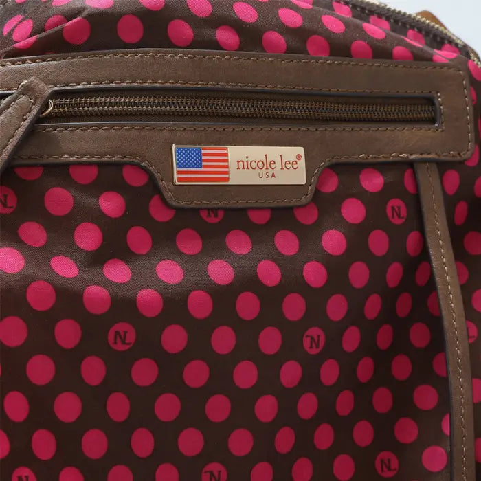 Handbag interior with vibrant pink polka dots on brown fabric, showcasing a stylish design.