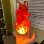 Handheld fireball prop emitting warm orange glow, flame-shaped design held in bedroom setting.