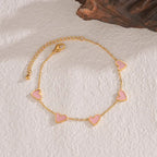 heart-charm-bracelet with pink hearts on gold chain displayed on textured surface, giving a soft romantic style ideal for 2025 gifting