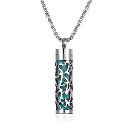 Aromatherapy pendant with heart pattern cutout and teal insert, made from stainless steel for essential oils.