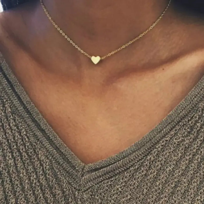 Dainty heart necklace styled with gray v-neck sweater showing everyday wear