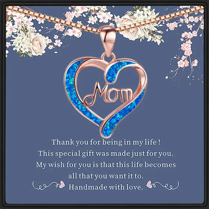 Rose gold heart-shaped mom necklace with blue opal inlay and floral background for Mother’s Day gift.