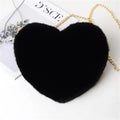 Black plush heart shoulder bag with gold chain strap on minimal background.