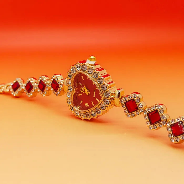 Heart stone watch with red jeweled dial shown at an angle highlighting crystal accents and gold bracelet design for elegant feminine style