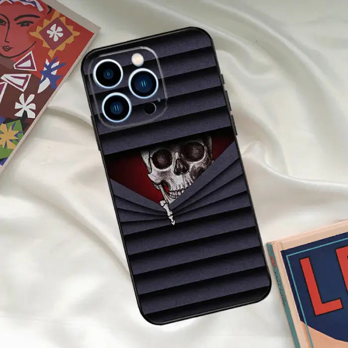 Hidden skull phone case with red and black striped design, creating a mysterious and eerie vibe.