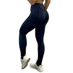 High-waisted navy leggings in rear view showing seam placement and snug, curve-hugging shape.