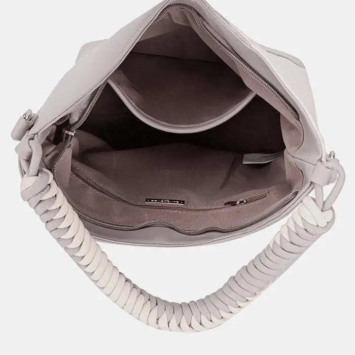 Interior view of hobo bag, revealing spacious compartments, zipper pocket, and dark lining