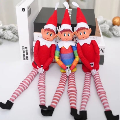 Three Christmas elves arranged on black boxes with festive garland background