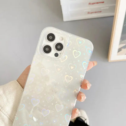 Clear phone case with holographic heart pattern held in hand, ideal for trendy smartphone protection.