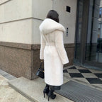 Back view of hooded long plush coat in white styled with black heels and bag.