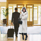 Hooded long plush coat in white styled indoors at a hotel lobby with elegant winter look.