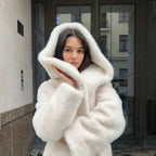 Hooded long plush coat in white styled for winter street fashion.