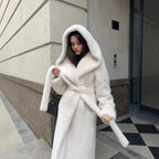 Hooded long plush coat in white with tie belt detail styled for sophisticated and cozy winter wear.