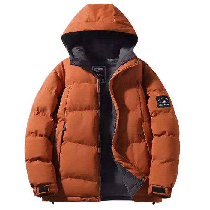  Hooded quilted puffer jacket with black interior in burnt orange, front angle showing puffy insulation and sleeve patch.
