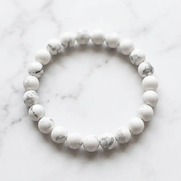 howlite stone polished bead bracelet on marble background emphasizing clean design and peaceful energy for stress reduction