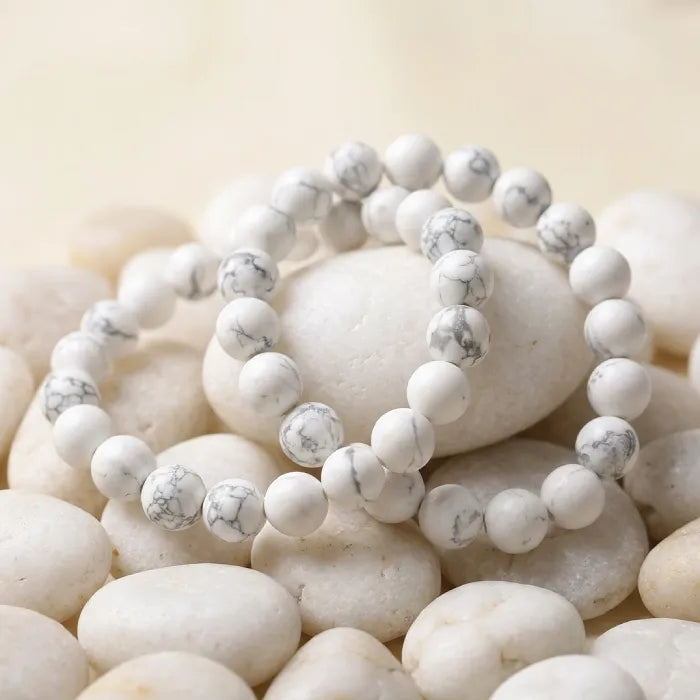 howlite stone white beaded bracelet on smooth spa stones with calming aesthetic promoting stress relief and mindfulness
