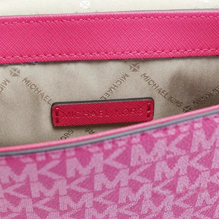 Inside view of Michael Kors pink bag, showcasing branded lining and spacious interior for essentials.