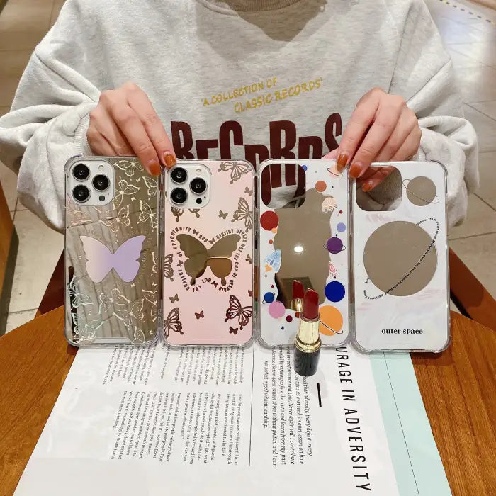 iPhone 15 case collection showing side-by-side comparison of butterfly-themed designs in pink and black alongside space-themed patterns