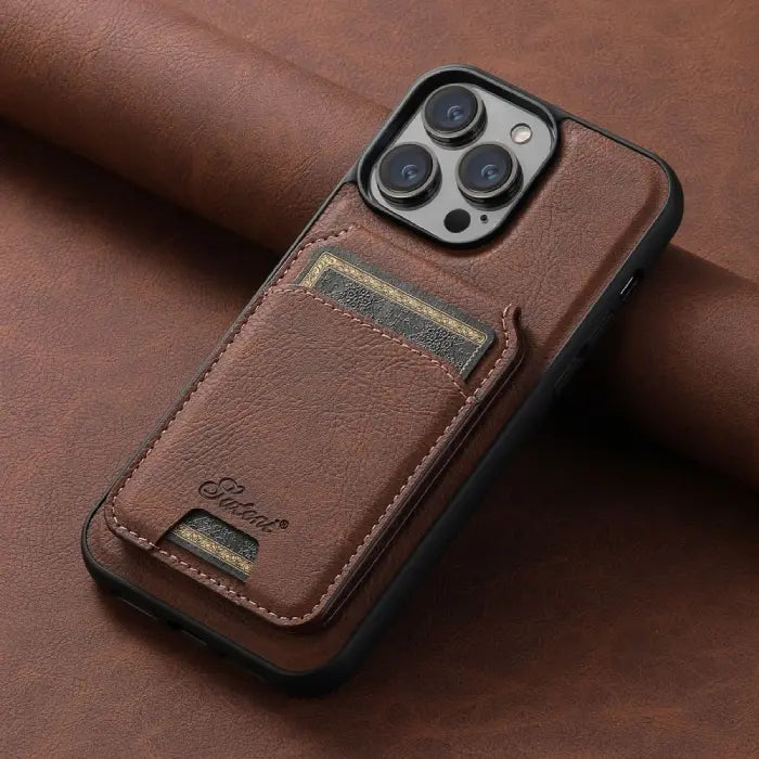 Brown leather iPhone case with stitched card holder pocket placed on matching leather background.