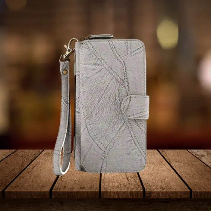 iPhone wallet case in gray leather with attached wristlet strap, snap closure and premium textured exterior for everyday carry