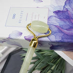Glowing jade roller on a decorative background with flowers and text