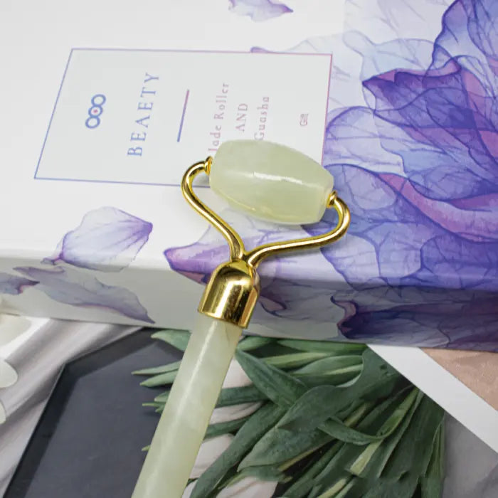 Glowing jade roller on a decorative background with flowers and text