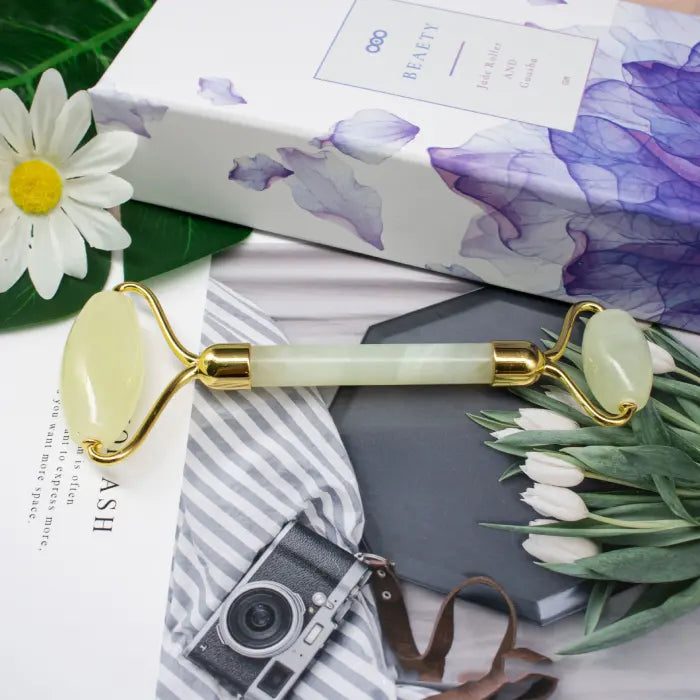 Beauty roller with gold accents on a floral and magazine background