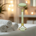Glowing jade roller on a bed with white towels and blurred lights in the background
