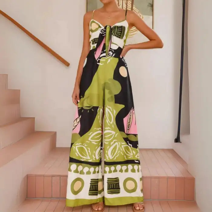 Jumpsuit with artistic green pink graphic and bow-tie front styled with spaghetti straps and wide legs.