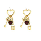 key and locket earrings featuring gold heart tops red heart crystals and dangling key and lock charms on white background