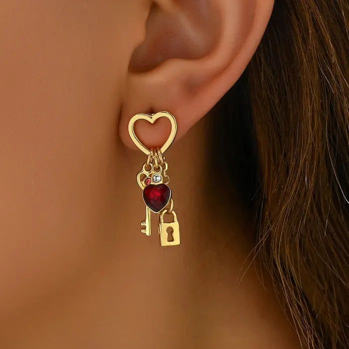 key and locket earrings with gold heart top red gemstone heart charm and dangling key lock worn on ear