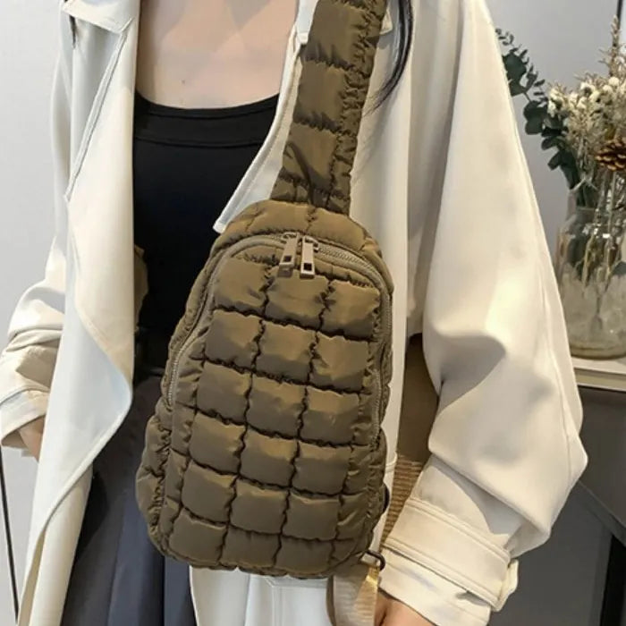 Khaki puffer sling bag worn with white blazer and black top, showcasing casual chic style