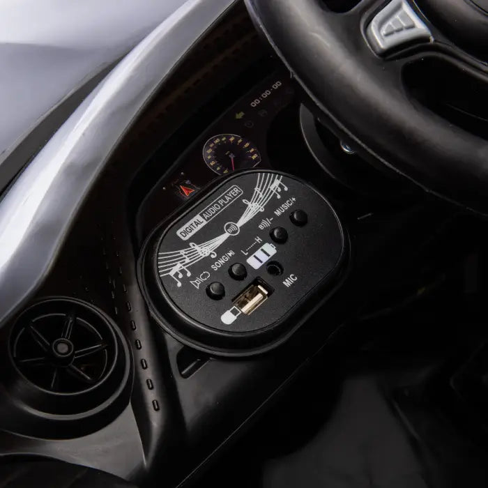 Close-up of digital audio player in kids' ride-on car, featuring USB port and music controls.