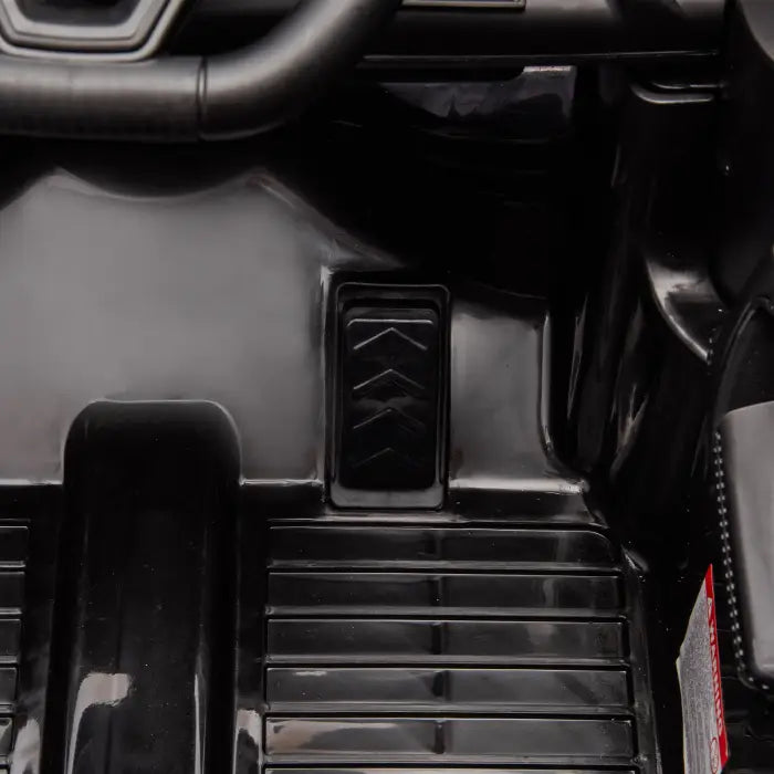 Close-up of gas pedal in kids' ride-on car, showcasing realistic driving features for young drivers.