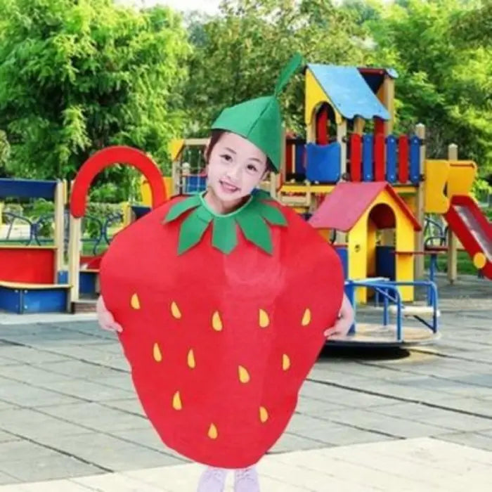 Child wearing strawberry kids costume with green hat, smiling in a colorful playground.