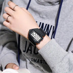  Black kids digital watch with white LCD screen, worn with casual hoodie outfit.