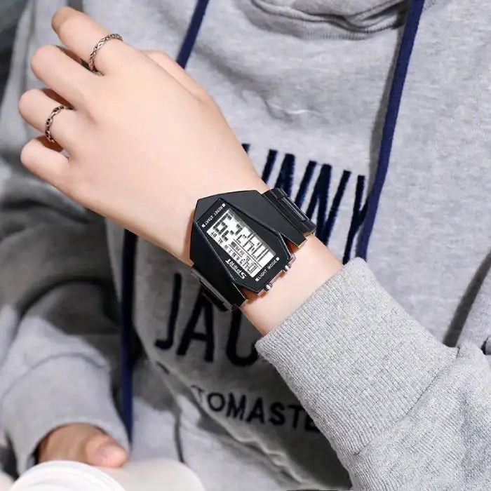 Black kids digital watch with white LCD screen, worn with casual hoodie outfit.