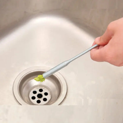 Kitchen pipe dredging tool removing debris from a sink drain.