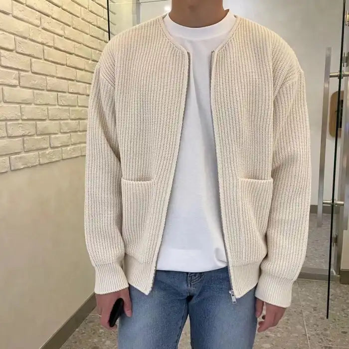 Knit Cardigan in cream with ribbed texture, zip front, and dual pockets worn over white tee and jeans.